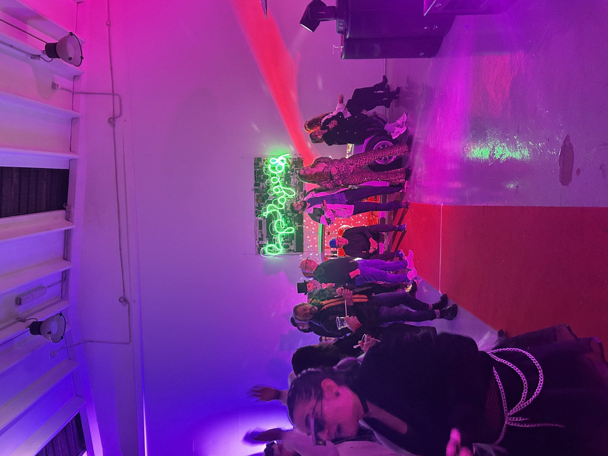 A crowd on the red carpet under neon