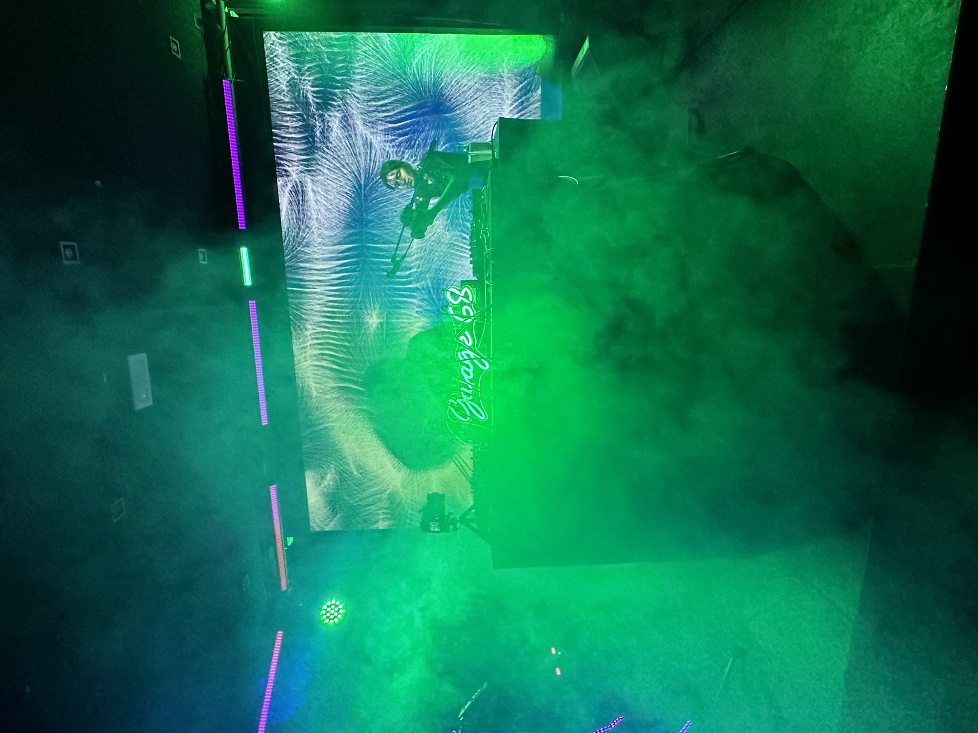 A DJ set behind the Garage 68 neon in fog
